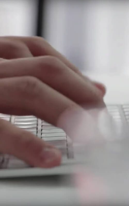 Hands typing on a laptop keyboard