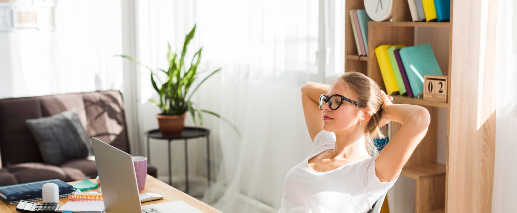 Woman relaxing at desk with laptop